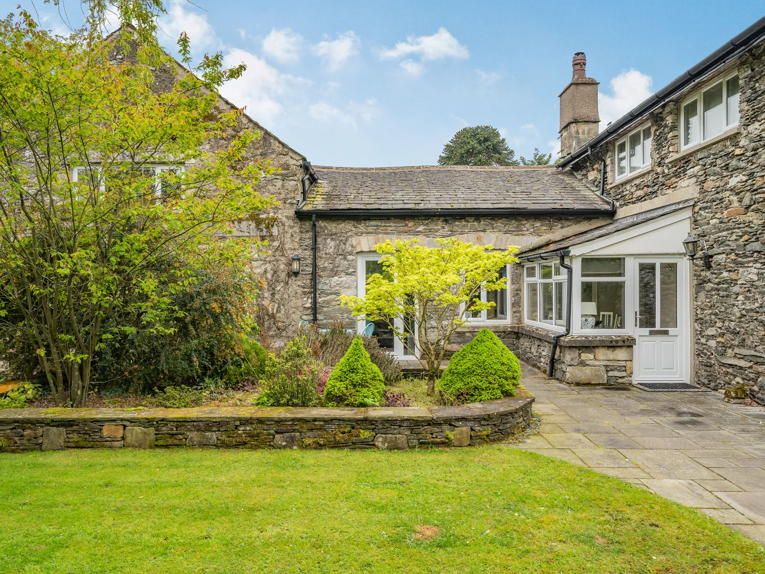 a stone house with a lawn and a garden